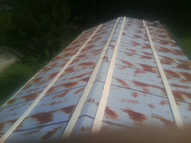 Rusted metal roof panels with new wood purlins before replacement — Storm Damage Roof Repair in Grafton by Roofing Brothers